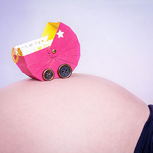 Babybauch farb - Aufnahme, selbstgebastelter Kinderwagen auf Bauch