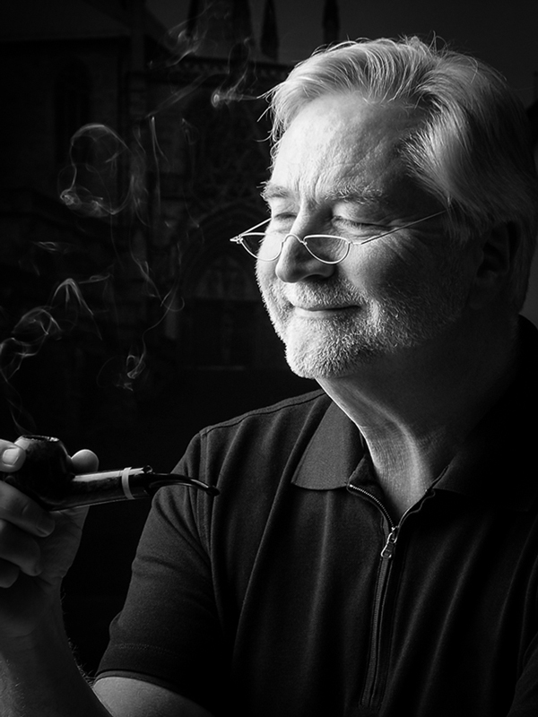 S/W- Portrait Mann sitzend im Studio am Pfeife rauchend